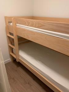 - deux lits superposés en bois dans une chambre dans l'établissement Cozy 30 m studio to enjoy the mountains, à Courchevel