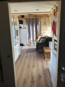 een woonkamer met een bank en een keuken bij Tiny house au cœur du marais in Saint-Omer