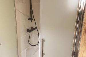a shower with a shower head in a bathroom at Tiny house au cœur du marais in Saint-Omer