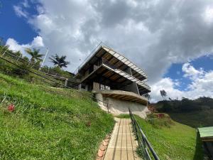 a building on the side of a grassy hill at Springfield Eco-Suites Guatapé in Guatapé