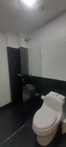 ein Badezimmer mit 2 WCs und einem Spiegel in der Unterkunft Suite Gold Hotel Omaga in El Peñol