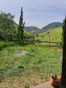 a fence in a field with a view of a hill at Fazenda Águas Claras in Mendes