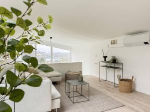 a white living room with a couch and a table at Scandi Micro House in Warstein