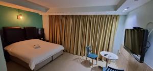 a small bedroom with a bed and a television at Marina Beach Hotel in Tel Aviv