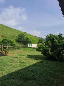 un campo de hierba con una valla y una colina en Fazenda Águas Claras en Mendes