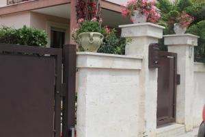 a gate with flower pots on the side of a house at B&B Flower House in Fasano