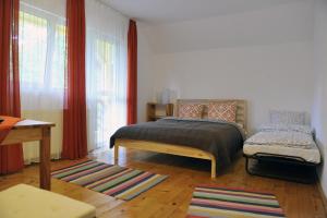 a bedroom with a bed and a window with red curtains at Pensiunea Tiuta in Corbeni