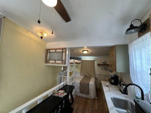 een kleine kamer met een bed en een kamer met een keuken bij Caretakers Apartment-Split level w/ European Bath in Wolfeboro