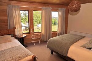 a bedroom with a bed and a large window at Lodge Cumbres de Chiloe in Castro