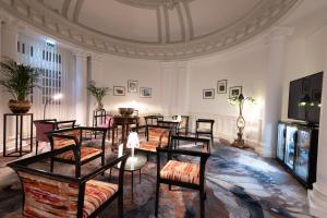 um quarto com cadeiras e mesas num edifício em Grand Hôtel Du Tonneau D'Or em Belfort