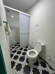 a bathroom with a toilet and a glass shower at Hotel CastilloMar in Cartagena de Indias
