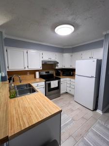 eine Küche mit weißen Schränken und einem weißen Kühlschrank in der Unterkunft Tequila Sunrise in Myrtle Beach