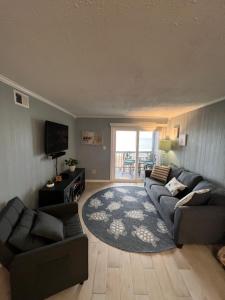 ein Wohnzimmer mit einem Sofa und einem TV in der Unterkunft Tequila Sunrise in Myrtle Beach