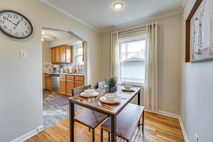 a dining room with a table and a clock on the wall at Beautiful Berkley Home about 18 Mi to Downtown Detroit in Berkley