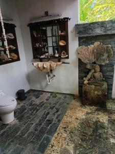 ein Bad mit einem WC und einem Steinkamin in der Unterkunft Artgarden Juan dolio in Juan Pedro