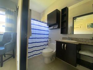 een badkamer met een toilet, een wastafel en een spiegel bij Dulce Refugio, Boquete, Panamá in Boquete