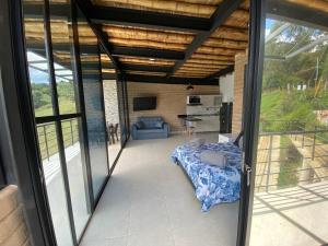 グアタペにあるSpringfield Eco-Suites Guatapéのガラスのスライドドア付きのリビングルームの景色を望めます。