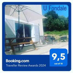a picnic table with an umbrella next to a trailer at Casa Fondale in Santa-Reparata-di-Balagna