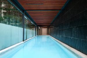 a swimming pool in a building with a wooden ceiling at Lumina at Taman Condesa in Mexico City