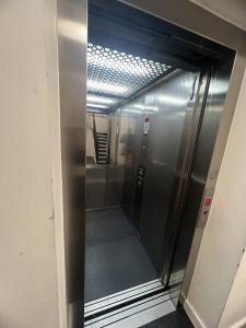 an elevator in an office building with a glass door at Private Flat in London in London