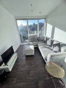 a living room with a couch and a flat screen tv at Private Flat in London in London