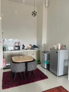 a kitchen with a table and two chairs and a refrigerator at KLIA Homestay Core Soho Suites by Yuyu Star Suites in Kampong Bekoh