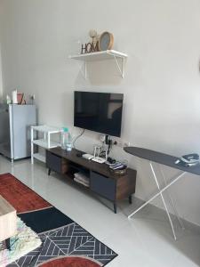 - un salon avec une télévision et une table dans l'établissement Yuyu Star Suites, à Kampong Bekoh