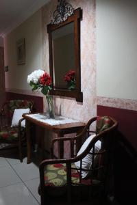 eine Vase aus Blumen auf einem Tisch mit einem Spiegel in der Unterkunft Hotel Toledo in David