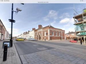 an empty city street with a large brick building at Warwick Centre Townhouse in Warwick