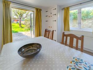 2 Bed in Isle of Purbeck IC096 في كورف كاسل: وعاء على طاولة في غرفة مع نافذة