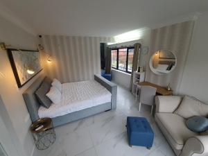 a small bedroom with a bed and a couch at Lazy Olives in Tongeren