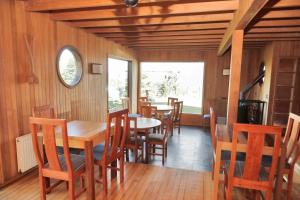 comedor con mesas y sillas de madera en Lodge Cumbres de Chiloe, en Castro
