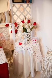 stół z wazonem róż na nim w obiekcie B&B Flower House w mieście Fasano