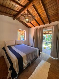 凱拉伊夫的住宿－Casa deck Caraíva，一间卧室设有一张床和一个大窗户