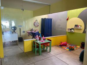 une chambre avec une table et des poupées à l'étage dans l'établissement Pousada Parracho, à Maracajaú