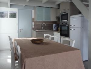 een keuken met een tafel en een mand erop bij Maison Rhéa in Rivedoux-Plage