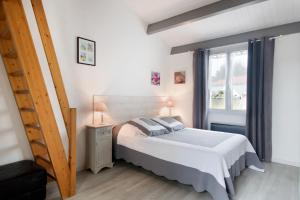 een slaapkamer met een bed en een raam bij Maison Rhéa in Rivedoux-Plage