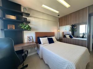 Schlafzimmer mit einem Bett, einem Schreibtisch und einem Stuhl in der Unterkunft Apartamento Vista Mar aconchegante no Rio Vermelho in Salvador