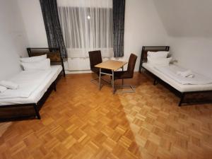 a room with two beds and a table and chairs at Ferienhaus mit Garten in Rastatt