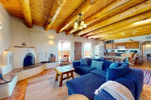 uma sala de estar com sofás azuis e uma cozinha em Casa de Encanto em El Prado