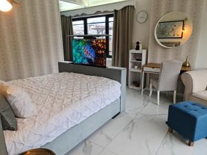 a bedroom with a bed and a desk and a mirror at Lazy Olives in Tongeren