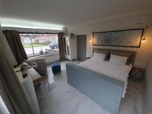 a bedroom with a bed and a living room at Lazy Olives in Tongeren
