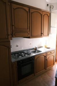 uma cozinha com armários de madeira, um fogão e um lavatório em Crosa Vacanze by PortofinoVacanze em Santa Margherita Ligure