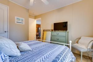a bedroom with a bed and a chair and a television at Pensacola Family Vacation Rental Home with Grill! in Pensacola