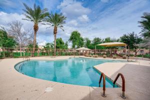 ein Pool mit Palmen im Hintergrund in der Unterkunft Glendale Getaway with Amenities 3 Mi to Westgate! in Glendale