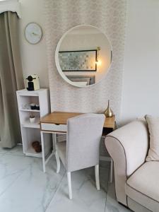 a room with a desk with a mirror and a couch at Lazy Olives in Tongeren
