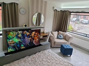 a living room with a large flat screen tv at Lazy Olives in Tongeren