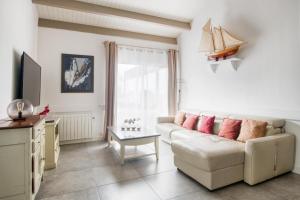 a living room with a couch and a table at Villa Odys in Rivedoux-Plage