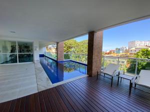 balcón con vistas a la piscina en Apartamento Vista Mar aconchegante no Rio Vermelho, en Salvador