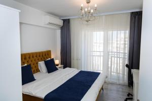 Un dormitorio con una cama grande y una lámpara de araña. en Top View Unirii Penthouse en Bucarest